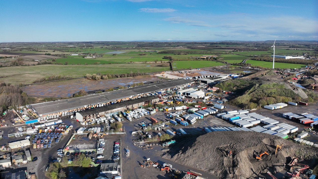 Aerial of open industrial storage, long shed and trailer yard at Simonswood.